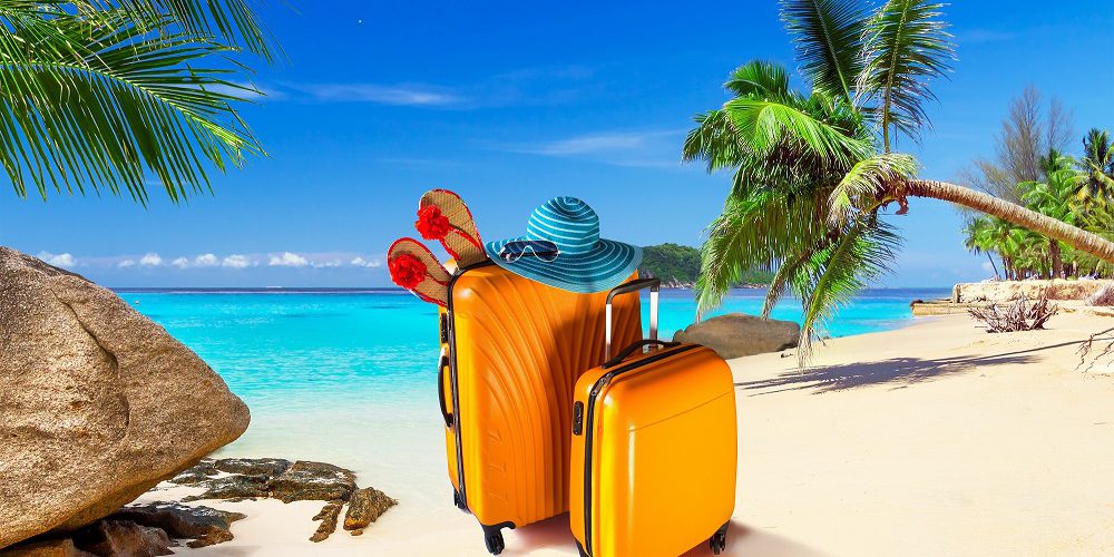 Summer holidays with baggages on the tropical beach